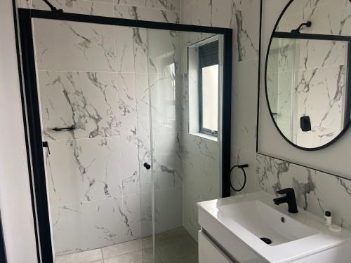 a white bathroom with a sink and a mirror at Lagoon Facing Apartment in Midrand