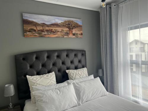 a bedroom with a bed and a painting on the wall at Lagoon Facing Apartment in Midrand