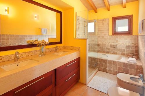 a bathroom with two sinks and a tub and a toilet at La Salve dalt in Pollença