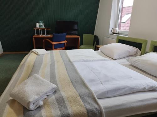 twee bedden in een hotelkamer met handdoeken erop bij Hotel Zdrojewo in Nowe