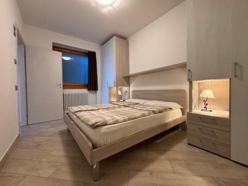 ein Schlafzimmer mit einem großen Bett und einem Fenster in der Unterkunft Casa Margherita Gravedona - Larihome A49 in Gravedona