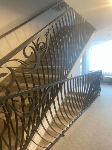 a spiral staircase with a metal railing in a building at Hotel Radetzky in Sankt Gilgen