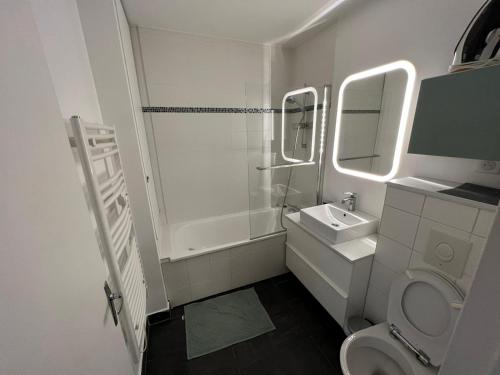 une salle de bain blanche avec un lavabo et des toilettes dans l'établissement Appartement calme à Bercy non loin de l'Accor Aréna, à Paris