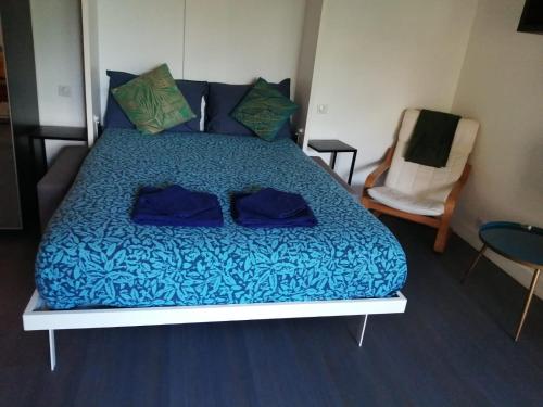 - un lit avec des draps et des oreillers bleus dans l'établissement Appartement calme à Bercy non loin de l'Accor Aréna, à Paris