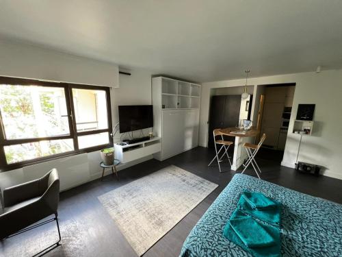 ein Wohnzimmer mit einem Bett und eine Küche mit einem Tisch in der Unterkunft Appartement calme à Bercy non loin de l'Accor Aréna in Paris