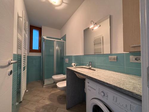 ein Bad mit einem Waschbecken, einem WC und einer Dusche in der Unterkunft Casa Margherita Gravedona - Larihome A49 in Gravedona