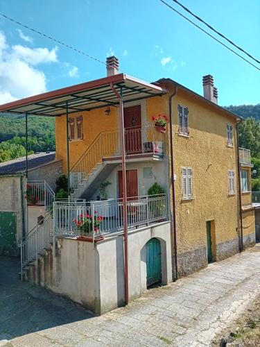 a yellow house with a balcony on a street at Agriturismo Ghirlanda Norma Rita in Carrodano Inferiore