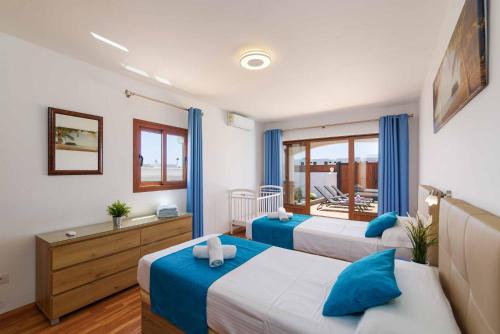 a bedroom with two beds and a balcony at Villa Palina in Puerto del Carmen