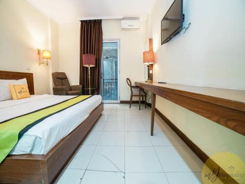 ein Hotelzimmer mit einem Bett und einem Schreibtisch in der Unterkunft Excellent Seven Hotel by My Hospitality in Bandung
