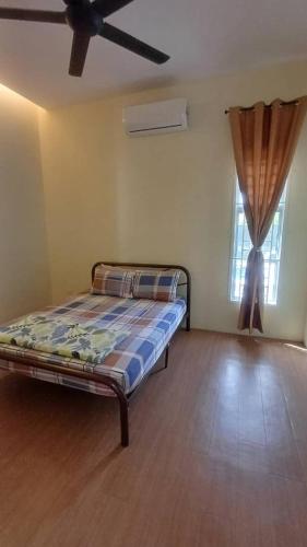 a bedroom with a bed in a room with a window at Tulz Homestay @ Melaka in Malacca