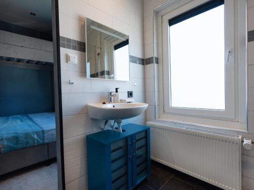 een badkamer met een wastafel en een spiegel bij Familiekamer B&B Gezond Aan Zee, 3 persoons, meerprijs voor wellness in Ouddorp