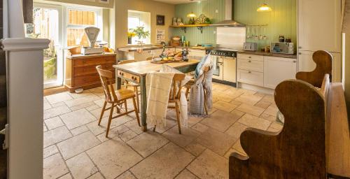 a kitchen with a table and chairs in it at Church Cottage by Coast & Country Stays in Beadnell