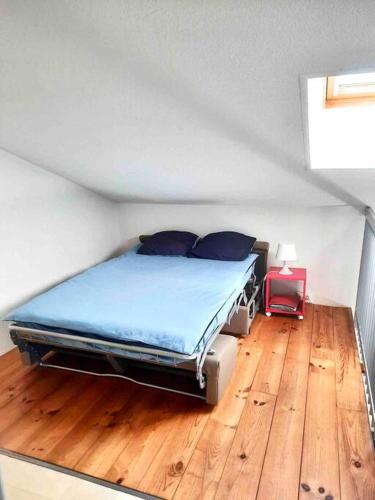 Cette chambre comprend un lit avec des draps bleus et du parquet. dans l'établissement Jolie maisonnette, à Palavas-les-Flots