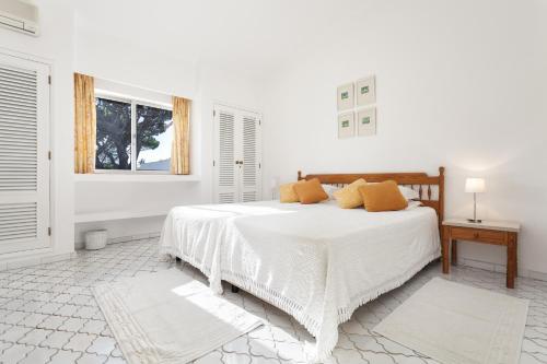 Una habitación blanca con una cama y una ventana en Villa Rosa, en Vale do Lobo