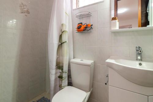 a white bathroom with a toilet and a sink at Manolis and Anna's House in Malona Village