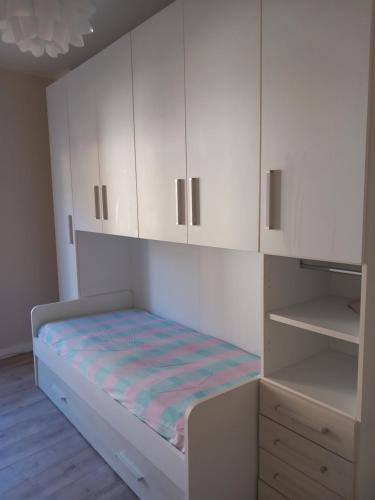 Camera bianca con letto e armadietti bianchi di La casa di Tina - Civenna a Civenna