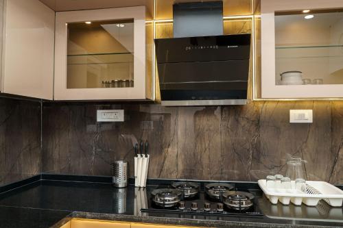 a kitchen with a stove top and cabinets at Williams Park Suite in Bangalore