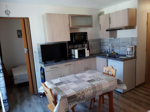 une cuisine avec une table et une cuisine avec une table et des chaises dans l'établissement Bernex T2 toute saison au pied des pistes, à Bernex