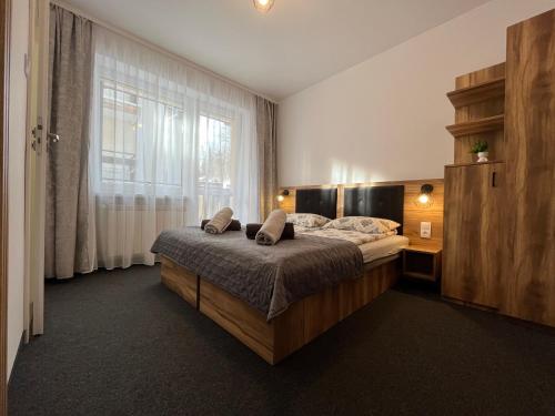 a bedroom with a bed and a large window at Willa Dorota in Krynica Zdrój