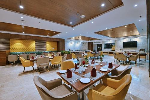 a restaurant with tables and chairs and a television at Quality Inn Elite Levelup Boutique in Amritsar