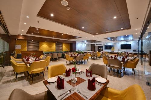 Quality Inn Elite, Amritsar في أمريتسار: مطعم فيه طاولات وكراسي في الغرفة