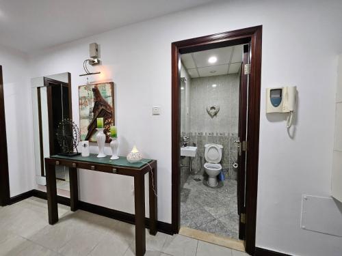 a bathroom with a toilet and a table with a sink at The Belvedere Marina Inn, Heart of Marina in Dubai