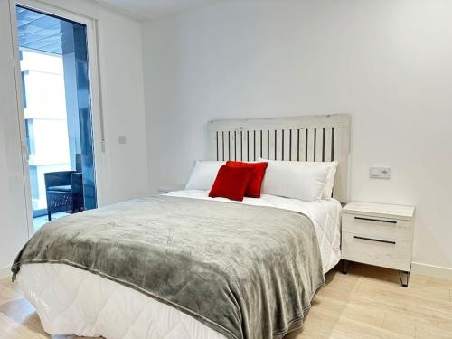 een slaapkamer met een bed met een rood kussen erop bij New Port, Free Parking YBH1L in Vigo