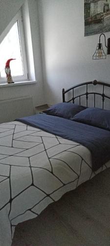 a bedroom with a bed with blue sheets and a window at Koteg LEMBERG in Slavske