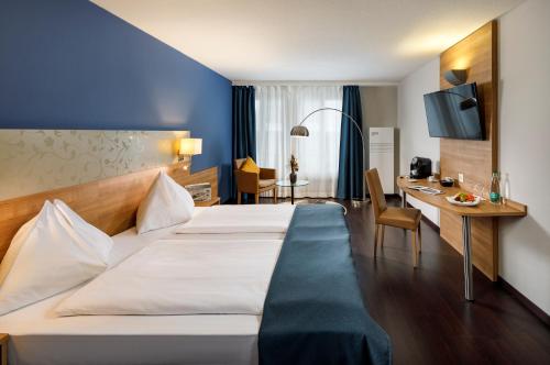 a hotel room with a bed and a desk at Hotel Olten Swiss Quality in Olten