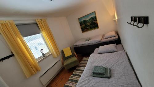 Habitación pequeña con 2 camas y ventana en Trevligt hus/stuga i Svärtinge, en Norrköping