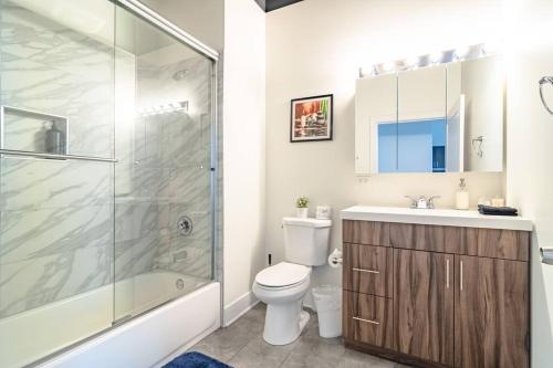 uma casa de banho com um chuveiro, um WC e um lavatório. em McCormick 2Br/2Ba family unit for up to 6 guests with Optional Parking & Gym access em Chicago