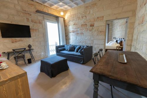 a living room with a blue couch and a table at Palazzo Sant'Anna Lecce in Lecce