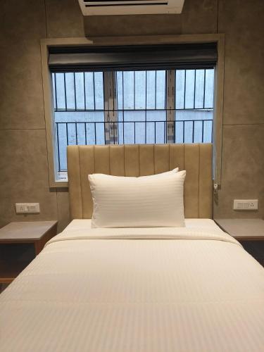 a white bed with a window in a room at Hotel Le Opera in Bengaluru