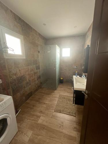 a bathroom with a sink and a washing machine at BH villa in Houmt Souk