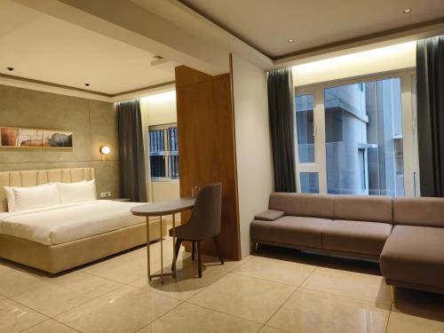 a hotel room with a bed and a couch at Olive Le Opera by Embassy Group in Bangalore