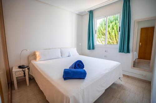 Un dormitorio con una cama con una toalla azul. en Arena Beach, en Corralejo
