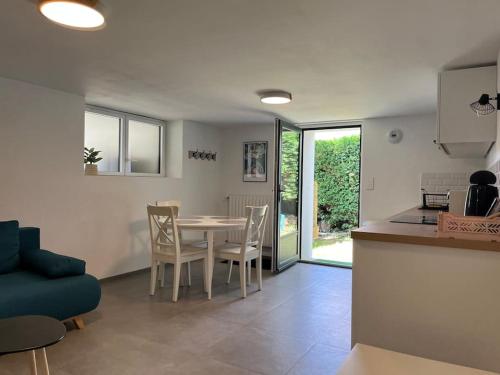 une cuisine et un salon avec une table et des chaises dans l'établissement Appartement Vannes avec jardin, à Saint-Avé