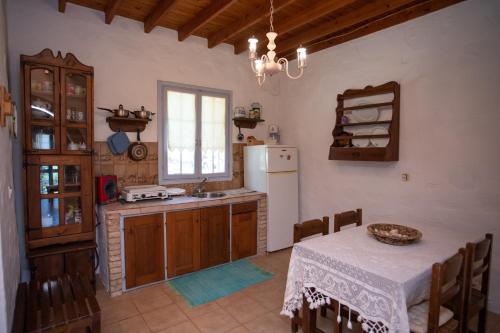 a kitchen with a table and a white refrigerator at Patmos Houses Tennis & Beach Tennis Court's in Patmos
