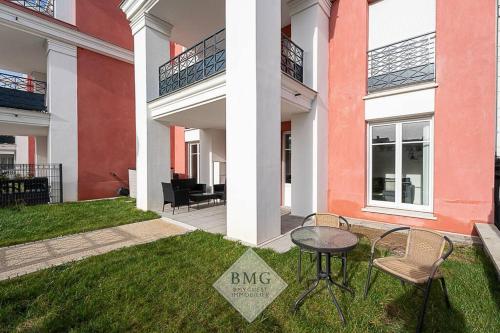 une maison avec une table et des chaises dans l'herbe dans l'établissement Scandinaves appartement Disneyland, à Serris