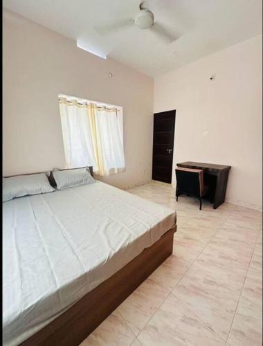 a bedroom with a large bed and a desk at Home at Guruvayur 2 AC Room,1 single bed,Kitchen in Guruvāyūr