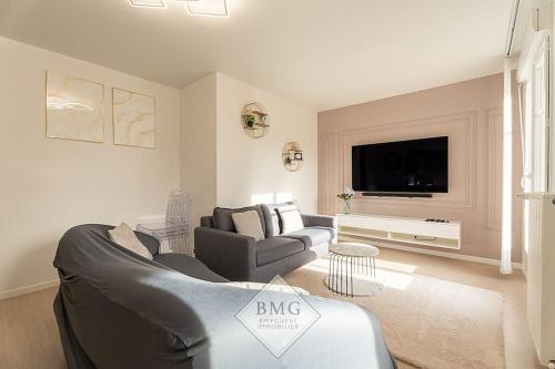 un salon avec un canapé et une télévision dans l'établissement Scandinaves appartement Disneyland, à Serris