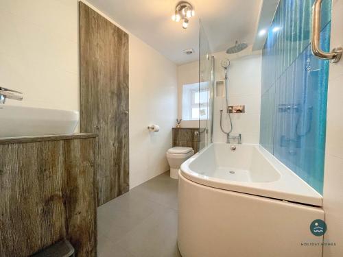 een badkamer met een bad, een toilet en een wastafel bij Cobb Cottage - Harbourside permit parking in Rodwell