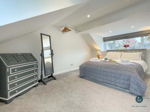 een slaapkamer met een bed, een dressoir en een spiegel bij Cobb Cottage - Harbourside permit parking in Rodwell