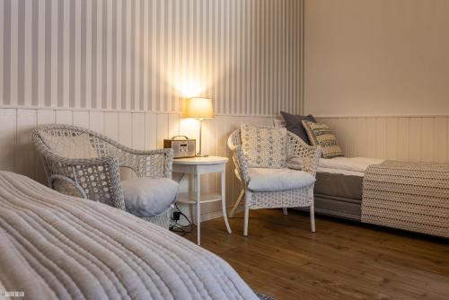 a bedroom with a bed and two chairs and a table at Liseleje Badehotel in Liseleje