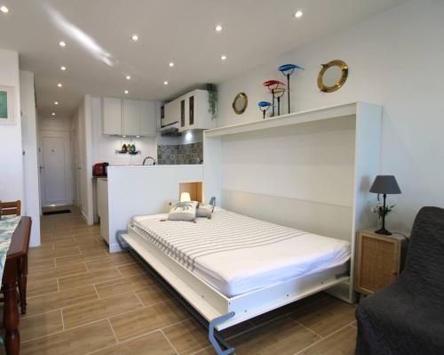 um quarto com uma grande cama branca num quarto em MARCOGVER - Golfe de St-Tropez - Studio pour 2 personnes vue sur la marina em Cogolin