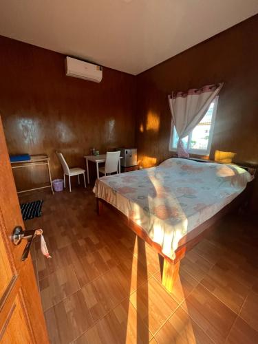 麥島的住宿－Baanlungmong，一间卧室配有一张床和一张桌子及椅子