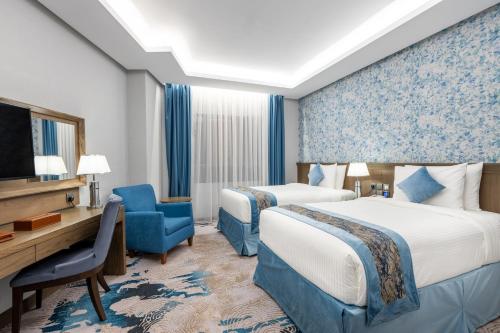 View Al Madinah Hotel في المدينة المنورة: غرفة فندقية بسريرين وتلفزيون