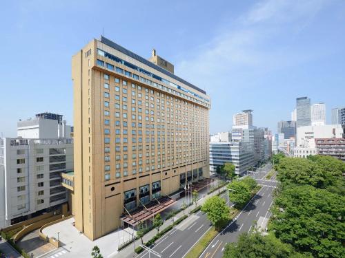 ein hohes Gebäude mitten in einer Stadt in der Unterkunft Nagoya Kanko Hotel in Nagoya