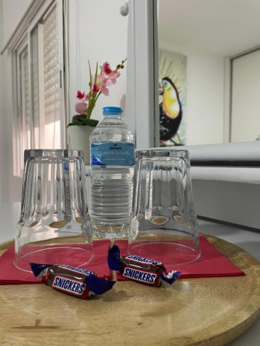 - une bouteille d'eau et deux verres sur une planche de découpe dans l'établissement Habitación Sol Connect, à Alicante