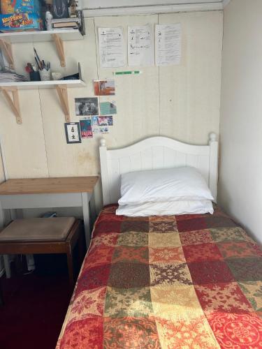 a bedroom with a bed with a quilt on it at Greenwich house in London